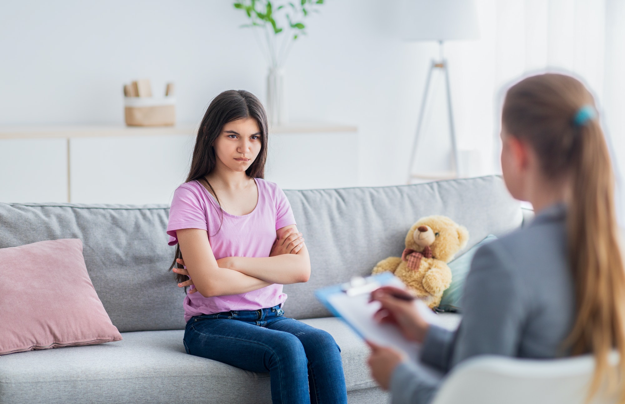 Unhappy Indian teen girl having session with psychologist at psychotherapy clinic